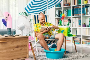 Man sending his holidays in his living room reading books